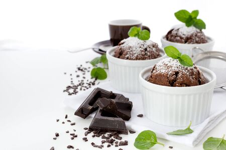 Chocolate muffins in white ramekins with leaves of mintの写真素材