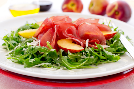 Fresh salad with bresaola, arugula,nectarine and cheese on white plateの写真素材