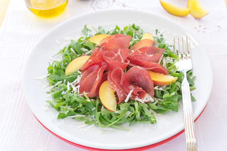 Delicious italian fresh salad with bresaola arugula and cheese on white plateの写真素材