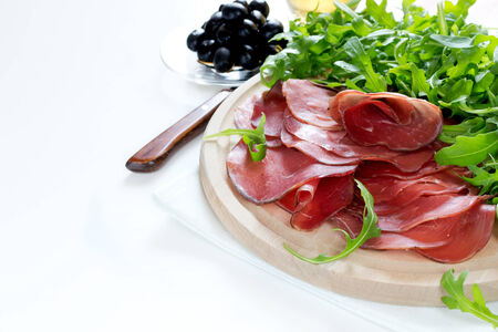 Italian smoked ham bresaola with arugula and oliveの写真素材