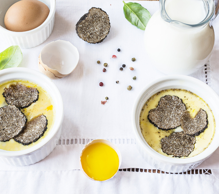 Omelette with black truffles in ramekins on white napkin.Top view.の写真素材