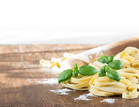 Tagliatelle pasta with basil on wooden table. Selective focus.の写真素材