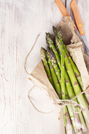 Fresh raw green Asparagus on black white wooden board. Selective focus, top view, free text space.の写真素材