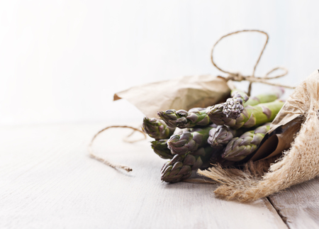 Fresh raw green Asparagus on black white wooden board. Selective focus, top view, free text space.の写真素材