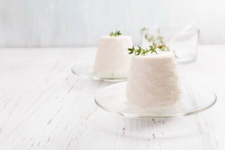 Italian ricotta cheese on glass plate on light background. Selective focus, free text space.の写真素材