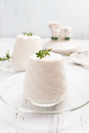 Italian ricotta cheese on glass plate on light background. Selective focus, free text space.の写真素材
