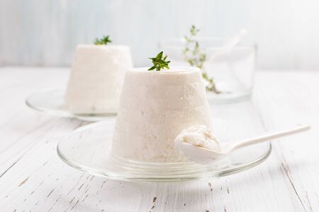 Italian ricotta cheese on glass plate on light background. Selective focus, free text space.の写真素材