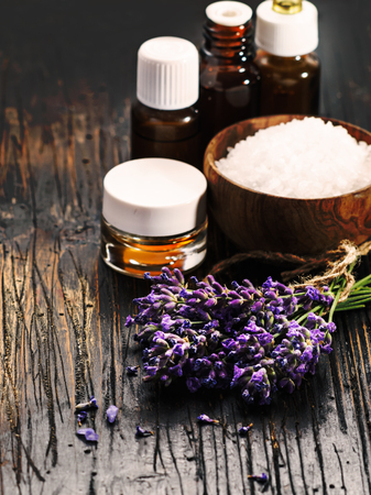 Lavender spa : bunch of lavender flowers , lavender oil and soap on a black wooden background.の写真素材