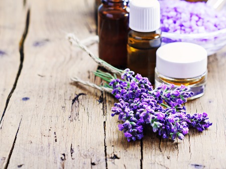 Lavender spa , bunch of lavender flowers , essential oil and salt on a rustic wooden background.の写真素材
