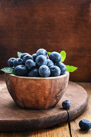 Blueberry in wooden bowl on rustic background.の写真素材