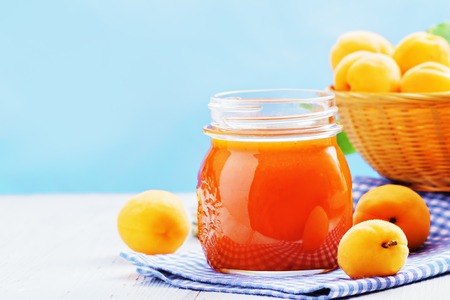 Apricot jam in a glass with apricots on a light background. Copy space.の写真素材