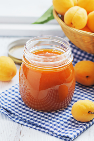 Apricot jam in a glass with apricots on a light background. Copy space.の写真素材