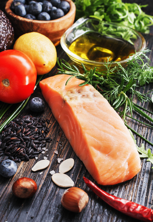 Selective of ingredients with fish and organic vegetables, cereals rich of amino acids,  oligominerals  for healthy seasonal cooking on black wooden background, top view, place for text.の写真素材