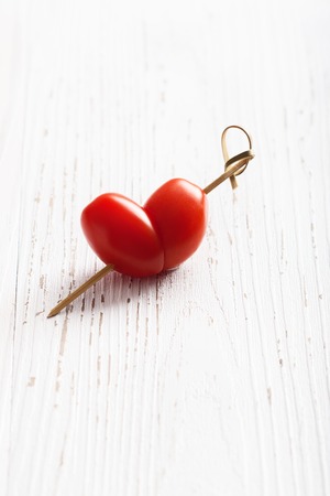 Cherry tomatoes shaped of heart, Valentines day and love theme.の写真素材