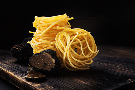 Strangozzi, italian wheat pasta with black  truffle on a black wooden  background.の写真素材