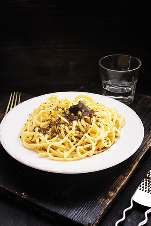 Strangozzi, italian wheat pasta with black truffle on a black wooden board.の写真素材