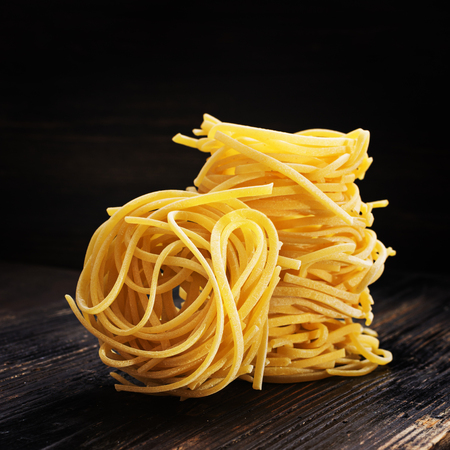 Strangozzi, italian wheat pasta with black  truffle on a black wooden  background.の写真素材