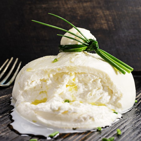 Burrata, fresh Italian cheese on a black wooden background.の写真素材