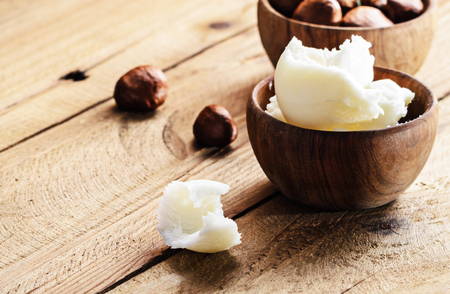 Shea butter and nuts on a wooden board, copy space.の写真素材