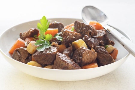 Beef meat stewed with carrots  in white plate.の写真素材