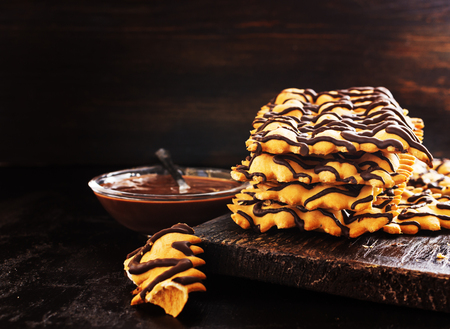 Italian Frappe or chiacchiere - typical Italian carnival fritters with chocolate on old black wooden table. With free text space.の写真素材