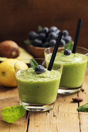Smoothie recipe with green spinach, almond on  wooden board. Well being and weight loss concept.の写真素材