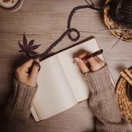Hand holding a pen on a woodenの写真素材