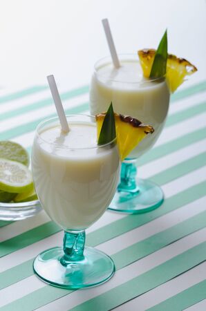 Milkshake with pineapple and coconut on green water stripesの写真素材