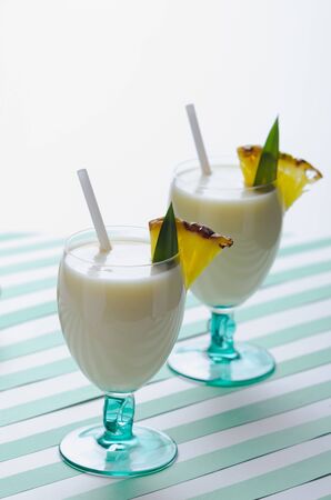 Milkshake with pineapple and coconut on green water stripesの写真素材