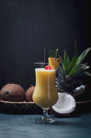 Tropical caribbean cocktail Pina Colada in a glasses on wooden  table with coconut and pineapple.の写真素材