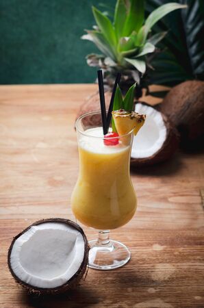 Tropical caribbean cocktail Pina Colada in a glasses on wooden  table with coconut and pineapple.の写真素材
