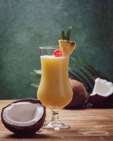 Tropical caribbean cocktail Pina Colada in a glasses on wooden  table with coconut and pineapple.の写真素材