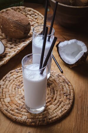 Coconut milk  in glasses with nuts on wooden board.の写真素材