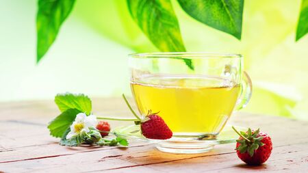 Cup with tea and strawberry on wooden table.の写真素材