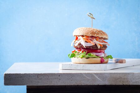 Burger with fermented foods kimchi, bbq beef cutlet on wooden over marble table.の写真素材