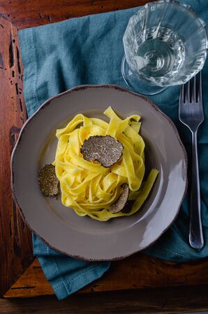 Italian cuisine- tagliatelle with black truffle on rustic plate.の写真素材