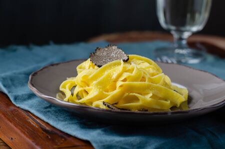 Italian cuisine- tagliatelle with black truffle on rustic plate.の写真素材
