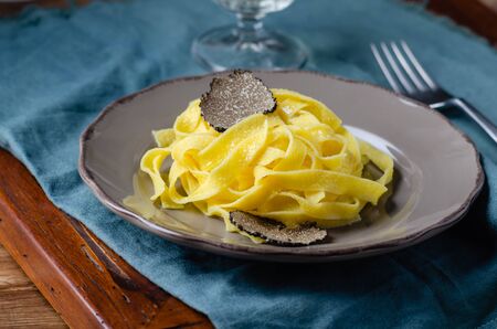 Italian cuisine- tagliatelle with black truffle on rustic plate.の写真素材