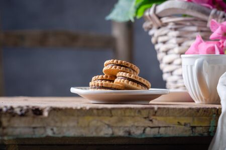 Still-life in the rustic style with cookies and hortensia flower in basket on wooden table.の写真素材