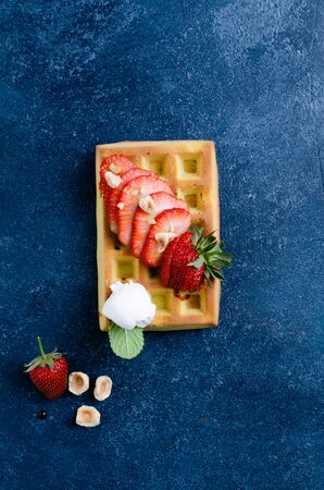 Belgian waffles with  summer fresh berries and honey on blue stone, Top view.の写真素材