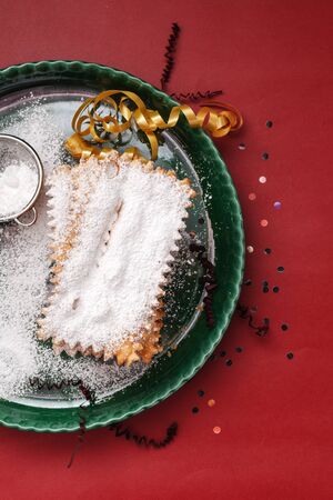 Typical carnival fritters dusted with powdered sugar on   table.の写真素材