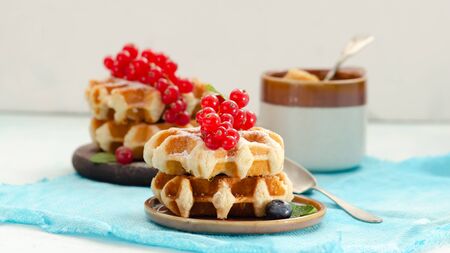 Breakfast with belgian waffles with honey caramel sauce and summer berriesの写真素材