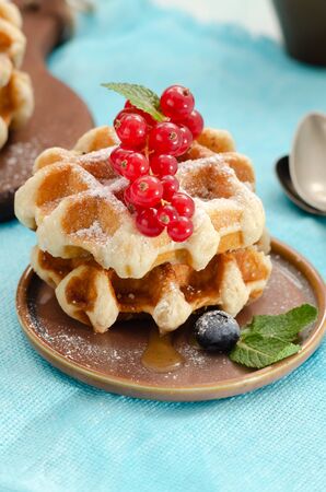 Breakfast with belgian waffles with honey caramel sauce and summer berriesの写真素材
