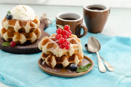 Breakfast with belgian waffles with honey caramel sauce and summer berriesの写真素材