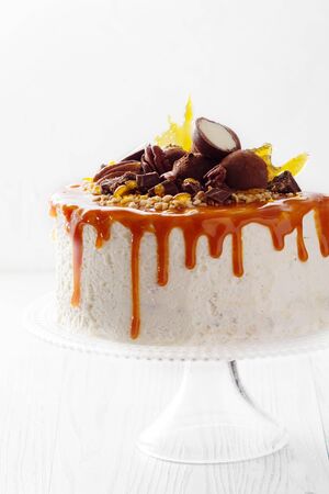 Festive cake with pecan nuts chocolate truffles  with streaks of caramel on  whiteの写真素材