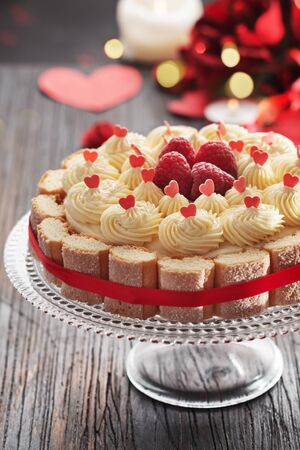 Cake with butter cream and fresh raspberries for Valentine's Day or mother's day on black woodenの写真素材