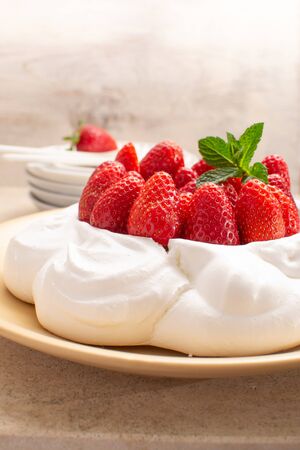 Strawberry Pavlova cake on beige plate.の写真素材