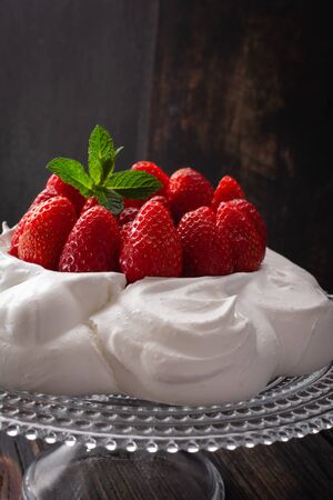 Strawberry Pavlova cake on glass plate  on black wooden table.の写真素材