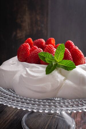 Strawberry Pavlova cake on glass plate  on black wooden table.の写真素材
