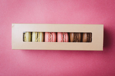 Gift box with macarons.  Colorful pink background.